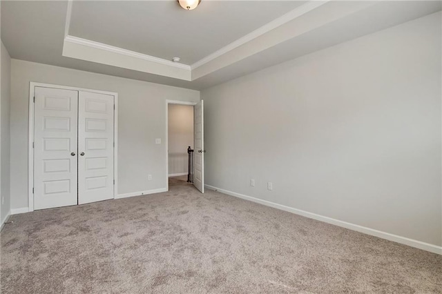 297 Delta Dr, Mcdonough, GA 30252 - unfurnished bedroom with carpet flooring, crown molding, baseboards, a raised ceiling, and a closet