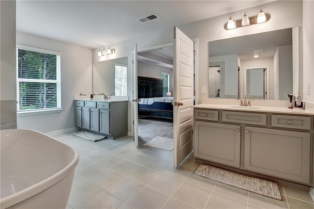 297 Delta Dr, Mcdonough, GA 30252 - full bath with two vanities, connected bathroom, a freestanding tub, tile patterned floors, and baseboards