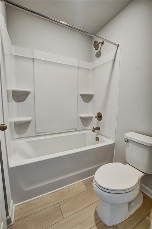 297 Delta Dr, Mcdonough, GA 30252 - bathroom with washtub / shower combination, toilet, and wood finished floors