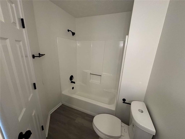 bathroom with toilet, shower / bathing tub combination, baseboards, and wood finished floors