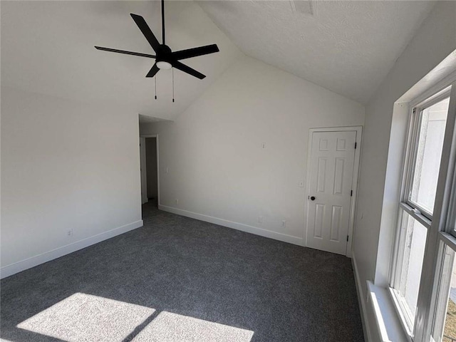 spare room featuring ceiling fan, baseboards, lofted ceiling, and dark colored carpet