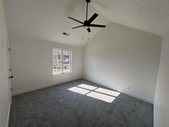 carpeted spare room featuring visible vents, a ceiling fan, a textured ceiling, baseboards, and vaulted ceiling