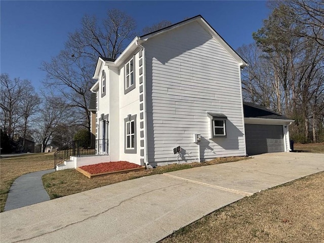 view of side of property with driveway and an attached garage