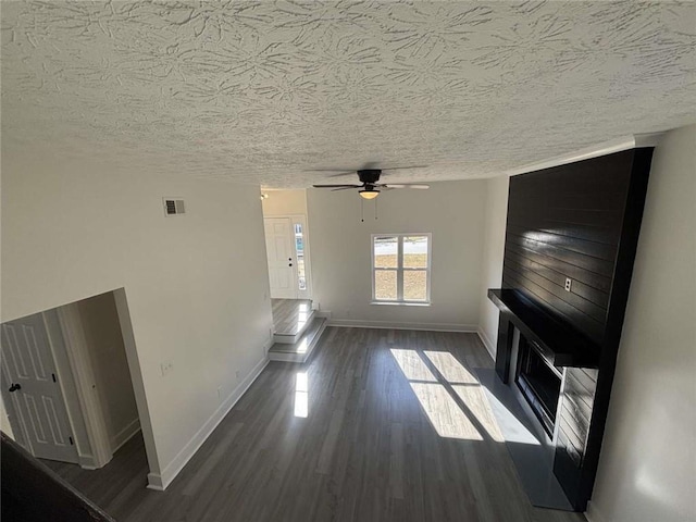 unfurnished living room featuring visible vents, baseboards, ceiling fan, and wood finished floors