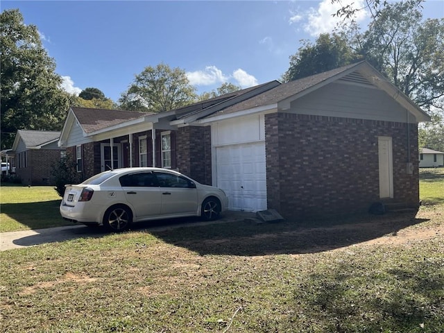 view of side of home featuring a garage and a lawn