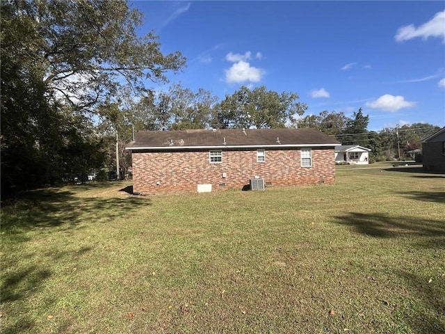 back of property featuring central AC and a yard