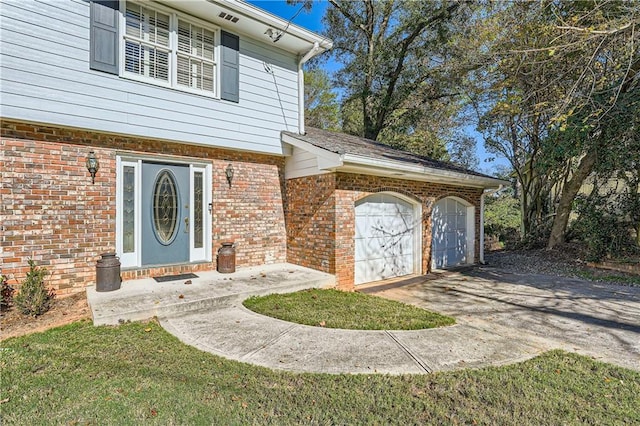 doorway to property with a garage and a lawn