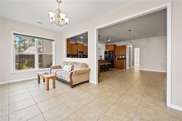 living room featuring a chandelier, baseboards, and light tile patterned floors