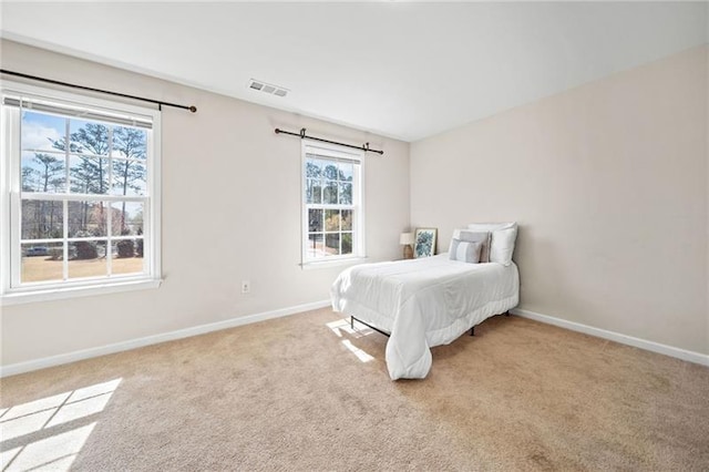 carpeted bedroom with baseboards and visible vents
