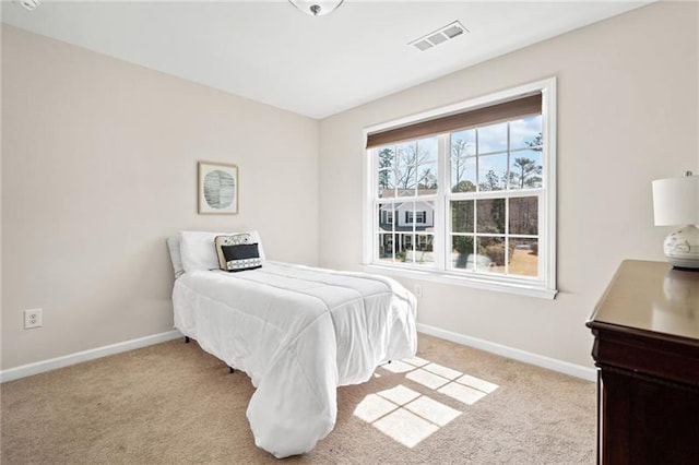 carpeted bedroom featuring baseboards and visible vents