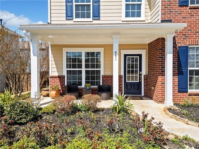 entrance to property with brick siding and covered porch