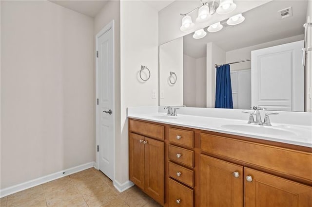 bathroom with tile patterned floors, double vanity, visible vents, a sink, and baseboards