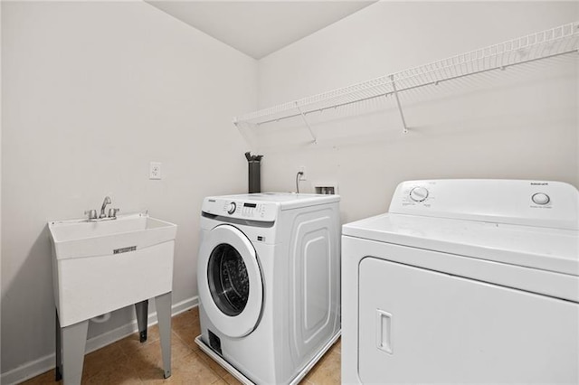 clothes washing area featuring washing machine and clothes dryer, baseboards, laundry area, and light tile patterned floors