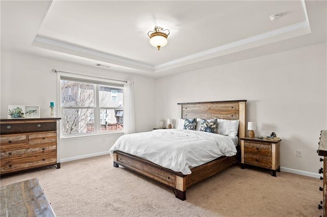 bedroom with baseboards, light carpet, a tray ceiling, and crown molding