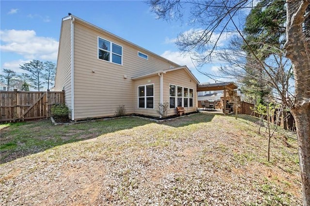 rear view of house with a fenced backyard