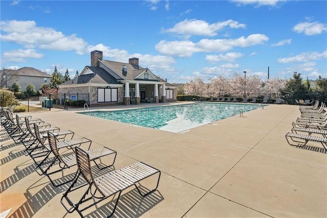 community pool featuring a patio and fence