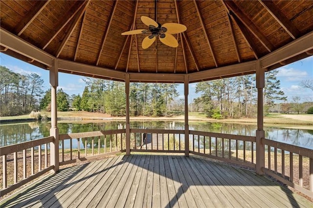deck with a gazebo, a water view, and a ceiling fan