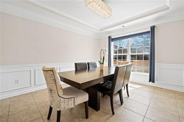 dining space featuring a tray ceiling, crown molding, and light tile patterned floors