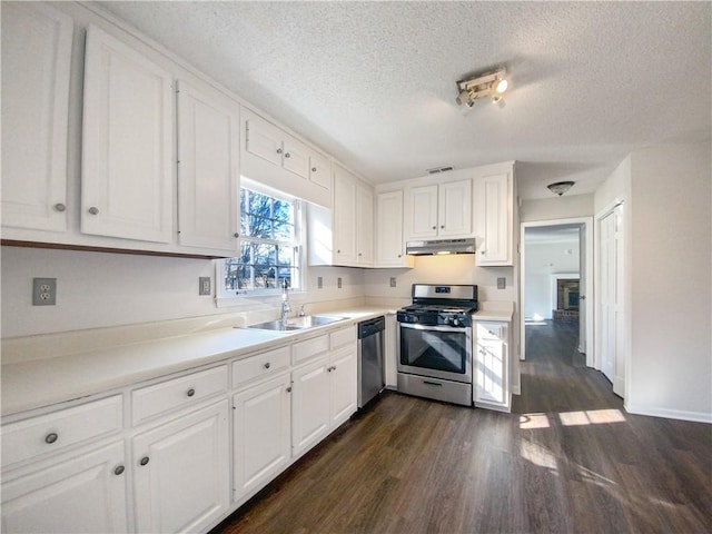 kitchen with stainless steel appliances, white cabinetry, and dark hardwood / wood-style floors