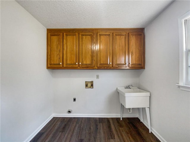 washroom with cabinets, hookup for an electric dryer, dark hardwood / wood-style floors, hookup for a washing machine, and a textured ceiling