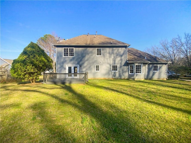 back of property featuring a lawn and a deck