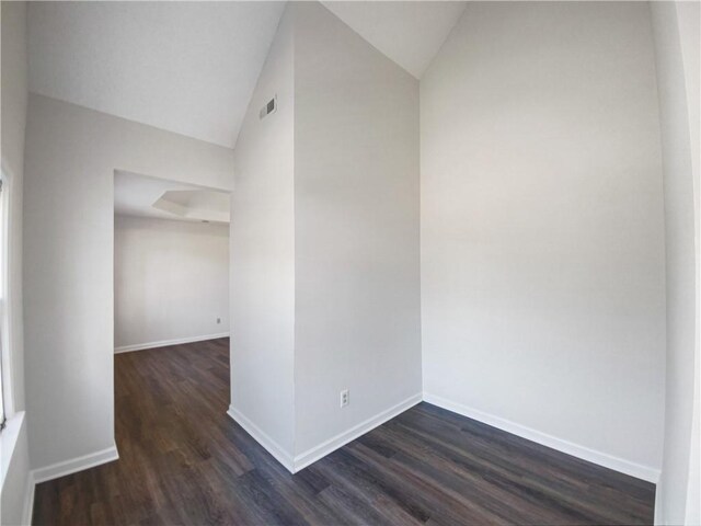 spare room with dark hardwood / wood-style flooring and lofted ceiling