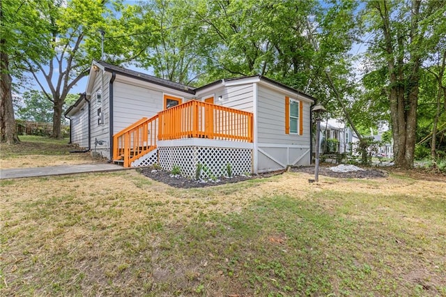 view of front facade featuring a front yard and a wooden deck