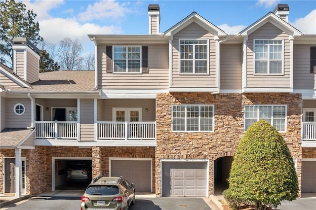407 The Crossings Ln, Woodstock, GA 30189 - townhome / multi-family property with stone siding, driveway, and an attached garage
