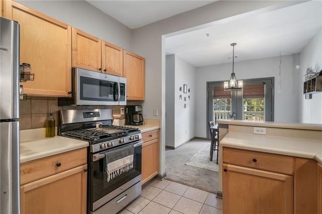 407 The Crossings Ln, Woodstock, GA 30189 - kitchen with light tile patterned flooring, light countertops, backsplash, stainless steel appliances, and decorative light fixtures