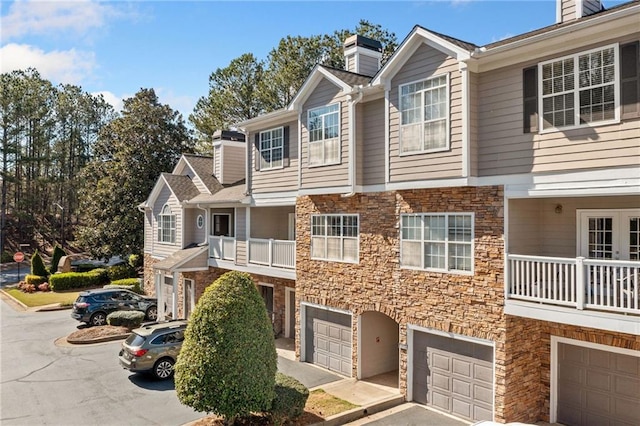 407 The Crossings Ln, Woodstock, GA 30189 - view of property featuring stone siding, an attached garage, and a chimney
