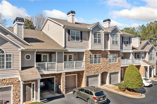 407 The Crossings Ln, Woodstock, GA 30189 - view of property featuring stone siding, driveway, a garage, and a chimney
