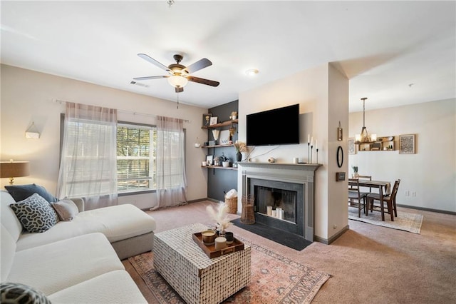 407 The Crossings Ln, Woodstock, GA 30189 - living area featuring a fireplace with flush hearth, carpet flooring, visible vents, baseboards, and ceiling fan with notable chandelier