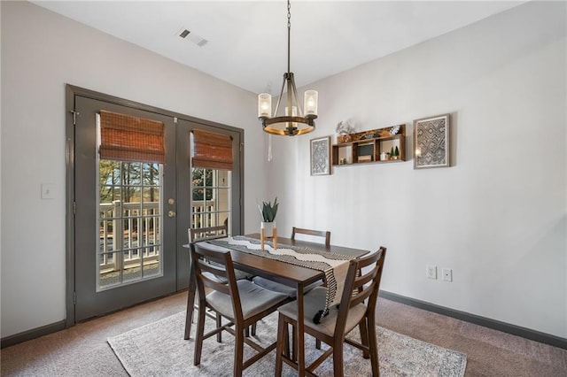 407 The Crossings Ln, Woodstock, GA 30189 - dining room with french doors, baseboards, visible vents, carpet, and an inviting chandelier