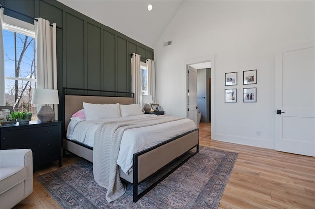 bedroom with multiple windows, light wood-style floors, and visible vents