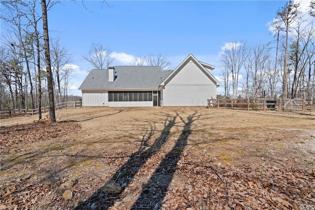 back of house featuring fence and a sunroom