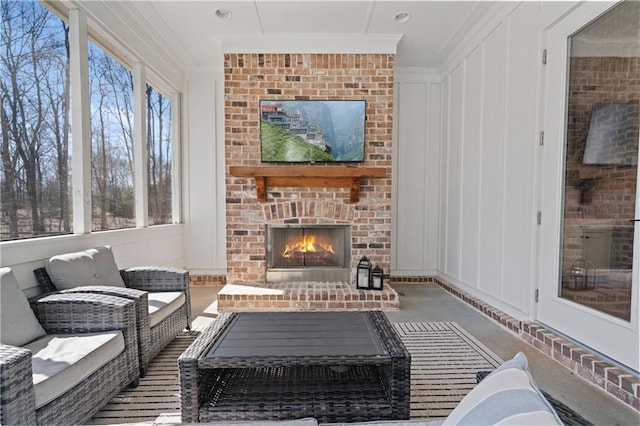 living area with ornamental molding, a fireplace, and a decorative wall