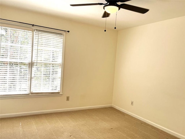 carpeted spare room with ceiling fan and plenty of natural light