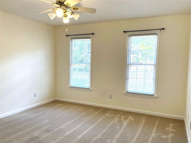 empty room with ceiling fan, carpet floors, and plenty of natural light