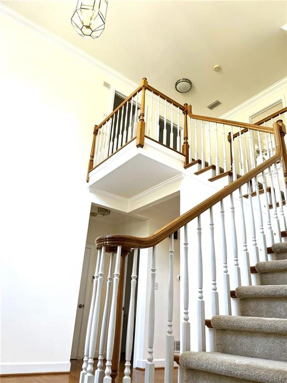 stairway featuring ornamental molding and hardwood / wood-style floors