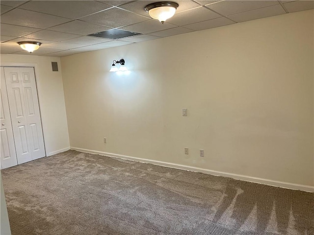 carpeted spare room featuring a paneled ceiling