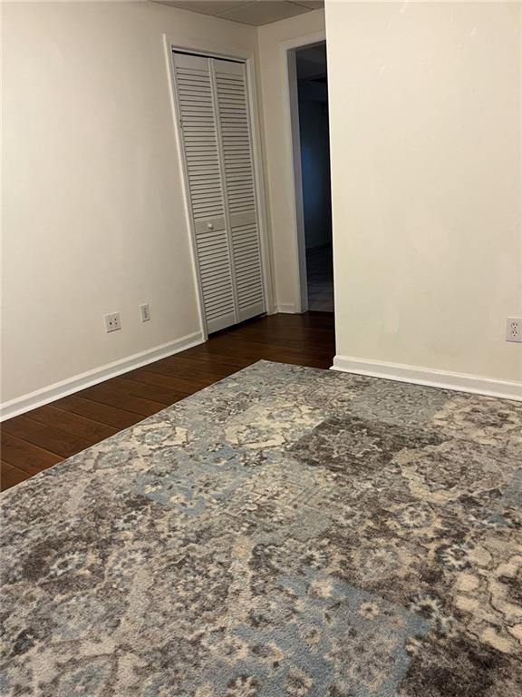 unfurnished bedroom featuring a closet and dark hardwood / wood-style floors