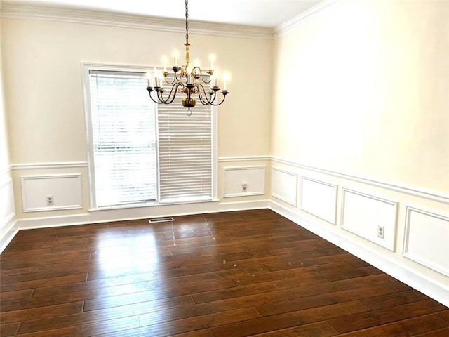 spare room with ornamental molding, dark wood-type flooring, and a notable chandelier