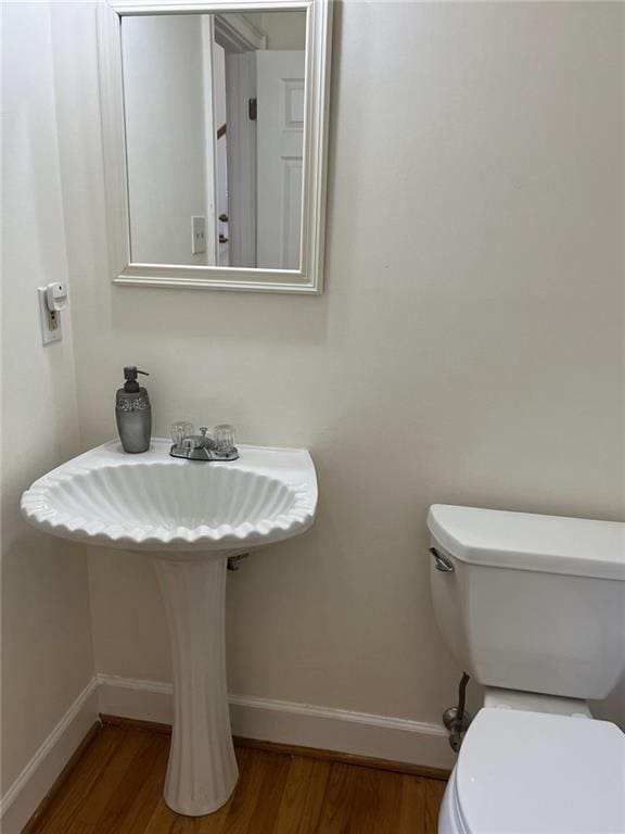 bathroom with toilet and hardwood / wood-style flooring