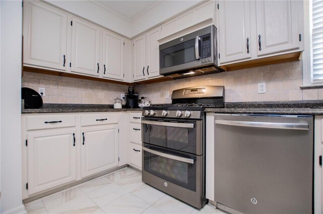 kitchen with white cabinets, appliances with stainless steel finishes, and backsplash