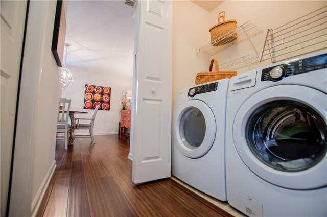 washroom with washer and clothes dryer and dark hardwood / wood-style floors