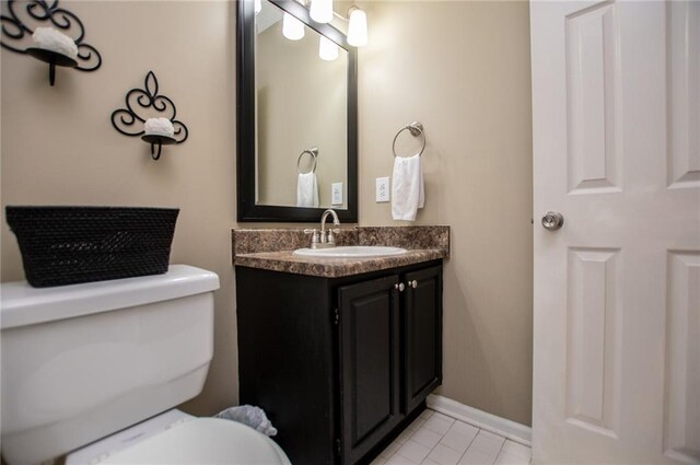 bathroom featuring tile patterned flooring, vanity, and toilet