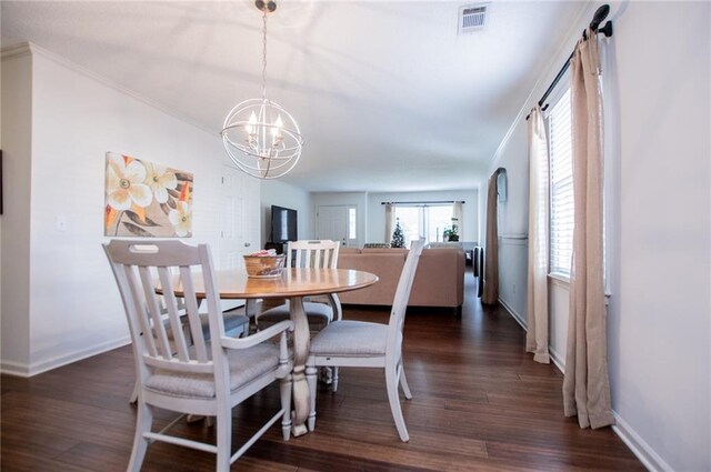 dining area with dark hardwood / wood-style flooring, crown molding, and a notable chandelier