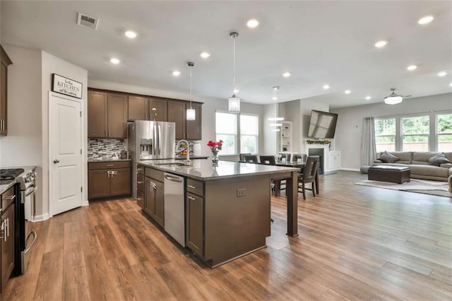 8 Unbridled Way, Newnan, GA 30263 - kitchen with stainless steel appliances, a sink, open floor plan, wood finished floors, and recessed lighting