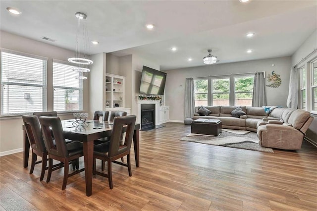 8 Unbridled Way, Newnan, GA 30263 - dining area with wood finished floors, recessed lighting, baseboards, a fireplace with flush hearth, and a chandelier