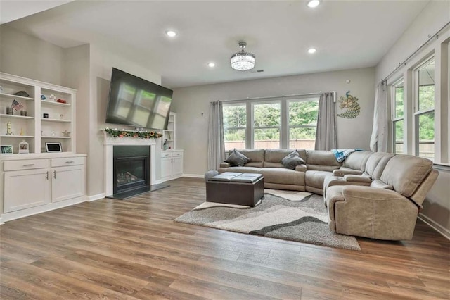 8 Unbridled Way, Newnan, GA 30263 - living room with healthy amount of natural light, recessed lighting, wood finished floors, a glass covered fireplace, and baseboards
